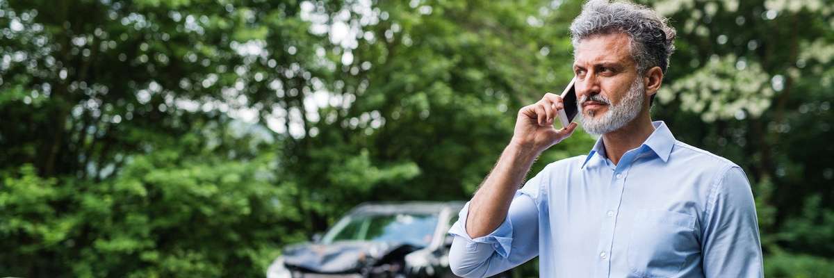 Man making a phone call after car accident